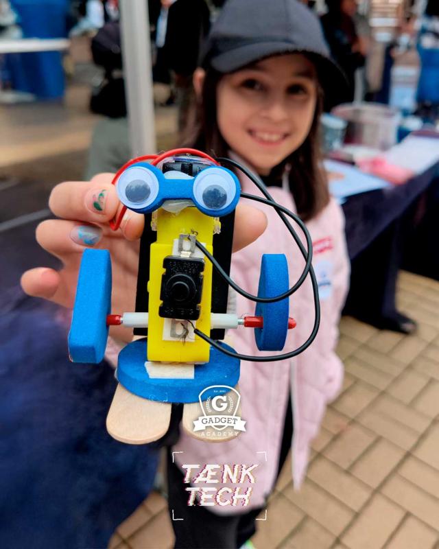 Barn viser mini robot til kamera